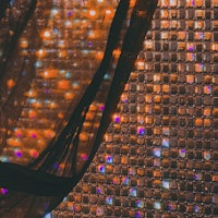 a close up of a mosaic wall with lights on it