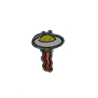 a pin with an egg on it on a black background