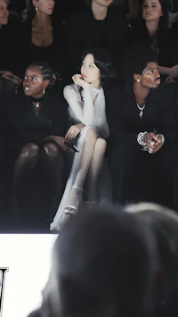 a group of people sitting in the front row of a fashion show