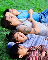 a group of young men laying on the grass