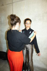 a woman is putting on a woman's pants