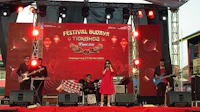 a group of people are performing on stage at an outdoor event
