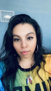 a young woman wearing a rainbow colored shirt