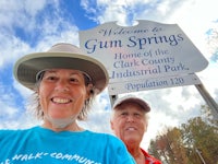two people standing in front of a sign that says gum springs