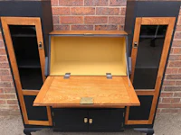 a black and wood desk with a bookcase on top