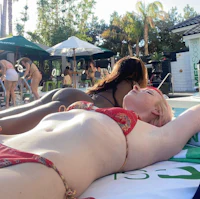a woman in a bikini laying on the beach