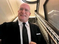 a bald man wearing a suit and tie