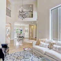 a large living room with a chandelier and white furniture