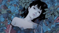 a woman is laying in the middle of a bunch of plants