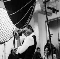 a woman taking a picture with a camera in front of a group of people