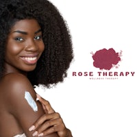 a woman with afro hair is smiling with the word rose therapy on her arm