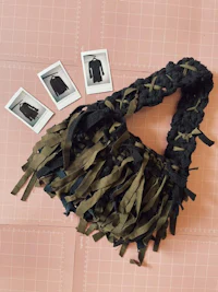 a bag with tassels and photos on top of it