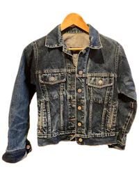 a denim jacket hanging on a hanger