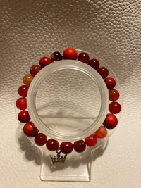 a bracelet with red jade beads on it