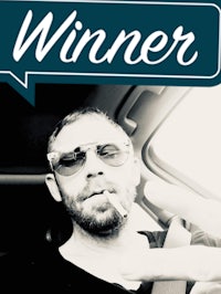 a man in a car holding a cigar with the words winner