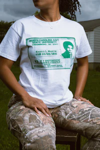 a woman wearing camo pants and a white t - shirt