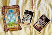 three tarot cards on a bed