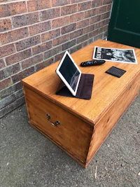 a wooden coffee table with a tablet on it
