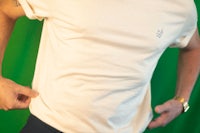 a man wearing a white t - shirt and black pants