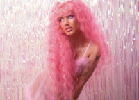 a woman with long pink hair posing in front of a glitter background