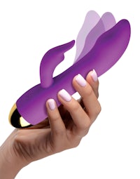 a woman's hand holding a purple vibrating toy