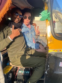 two people in a tuk - tuk posing for the camera