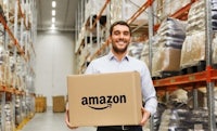a man holding an amazon box in a warehouse