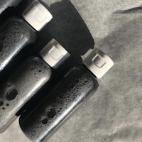 a set of black soap bottles on a piece of paper