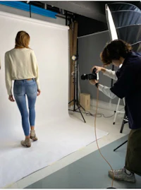 a woman is standing in front of a camera in a studio