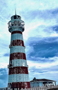 a red and white lighthouse on a pier