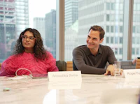 a group of people sitting around a table in a conference room
