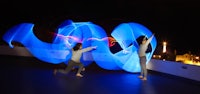 a group of people doing hula hooping at night