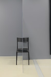 a black chair in a room with a curtain