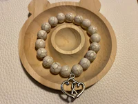 a bracelet with a heart and a teddy bear on it