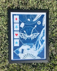 a framed print of playing cards with a butterfly on it