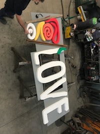 a man is working on a sign that says love