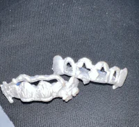 a pair of silver teeth on a black cloth