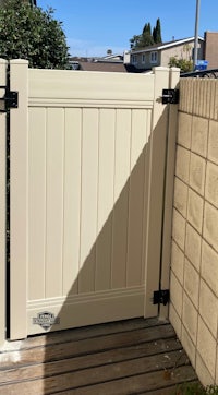 a white fence with a black gate