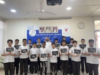 a group of boys holding certificates in front of a banner