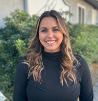 a smiling woman wearing a black turtle neck top