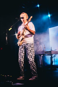 a man playing a guitar on stage