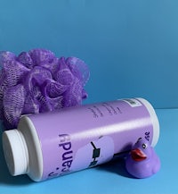 a bottle of purple soap with a rubber duck next to it