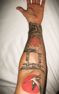 a man with a tattoo of a bird on his arm