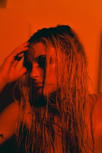 a woman with wet hair sitting in a bathtub