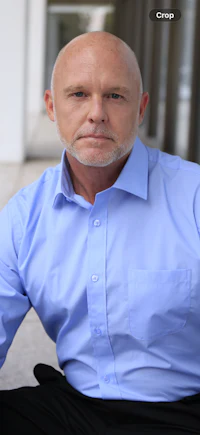 a bald man in a blue shirt and black pants