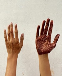 two hands with henna tattoos on them