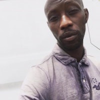 a man in a purple shirt is taking a selfie