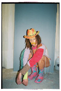 a woman in a colorful outfit crouching on the floor
