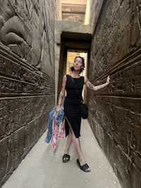 a woman posing in front of an egyptian temple