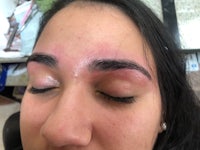 a woman with her eyes closed and eyebrows pierced